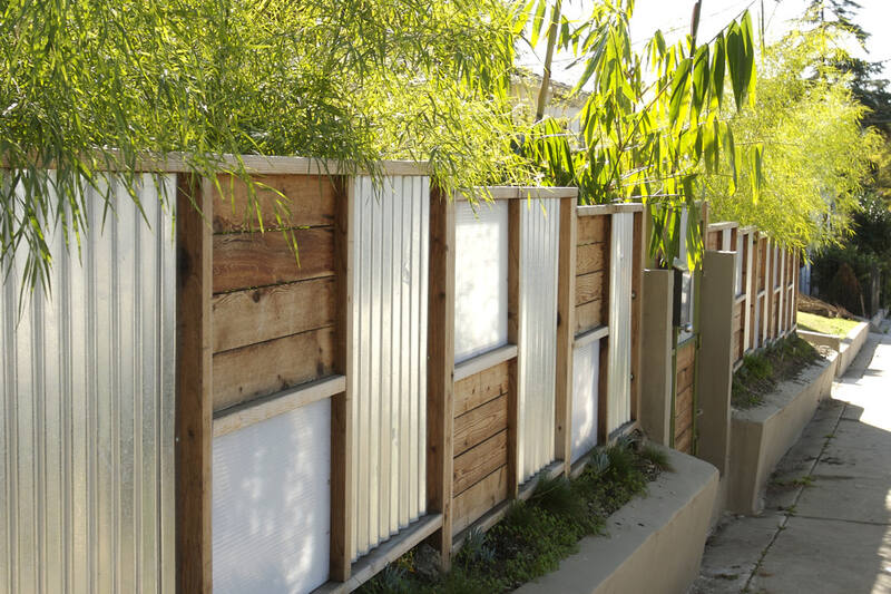 Modern horizontal timber and corrugated metal designer fence with bamboo